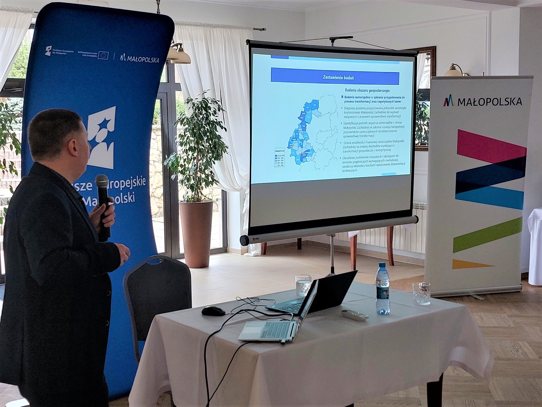 Pracownik Departamentu Rozwoju Regionu omawia plan badań, który będzie realizowany w latach 2026-2028 w ramach projektu "Budowanie sieci współpracy oraz monitoring procesu sprawiedliwej transformacji w województwie małopolskim"